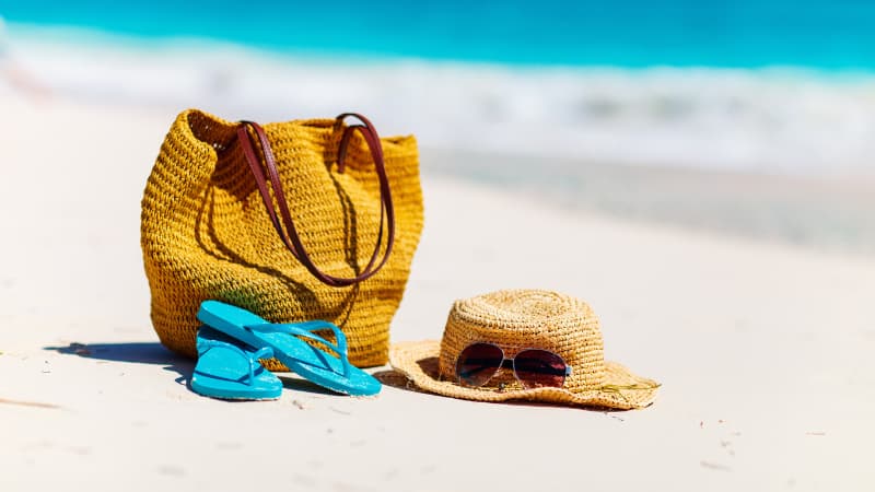 Bag, thongs, hat and sunglasses on a beach
