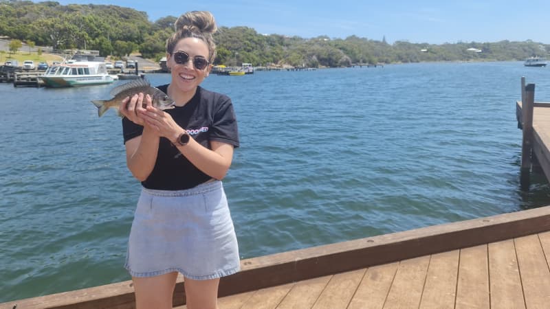 Nadia holding a fish caught at Ellis St Jetty. River in the background.