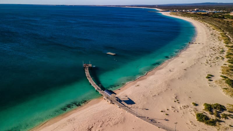 Jurien Bay foreshore from above. Beach curves around and jetty is in the centre of the frame.