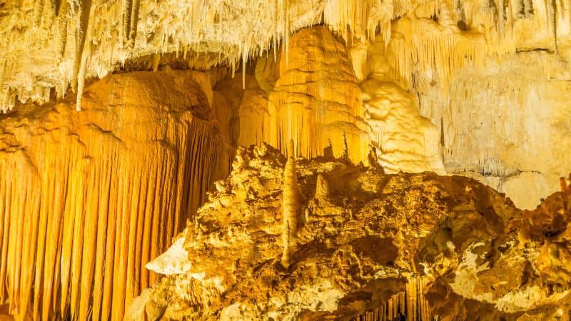 Calcite formations in Jewel Cave lit by golden light