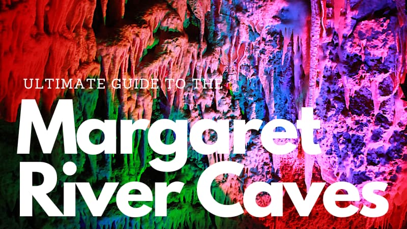 Calcite formations in Ngilgi Cave with rainbow lights projected on them. Text reads "Ultimate Guide to the Margaret River Caves"
