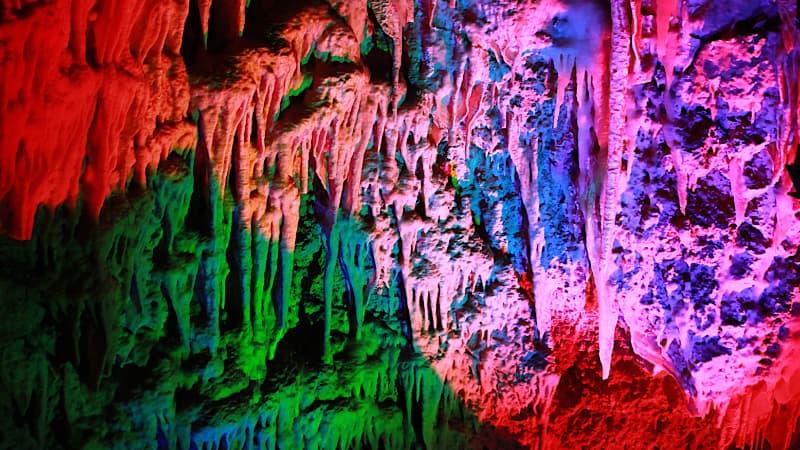 Blue, green, pink and red lights light up the walls on Ngilgi Cave in Margaret River