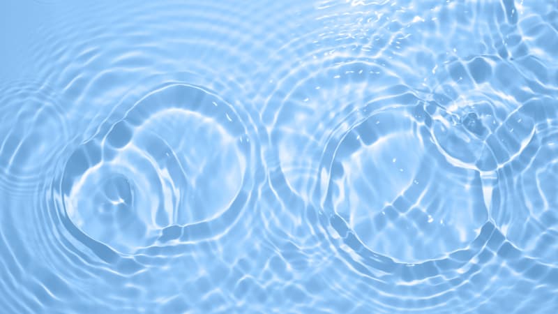 Circular water waves over a light blue background