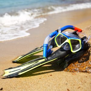 Snorkel, mask and fins on the sand of the beach
