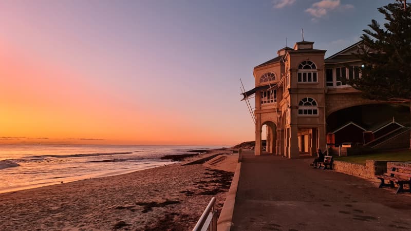 Sun sets over the Indian Ocean and Indiana Teahouse at Cottesloe Beach