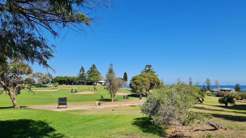 Rolling hills of the Cottesloe Golf Club course with the ocean in the background