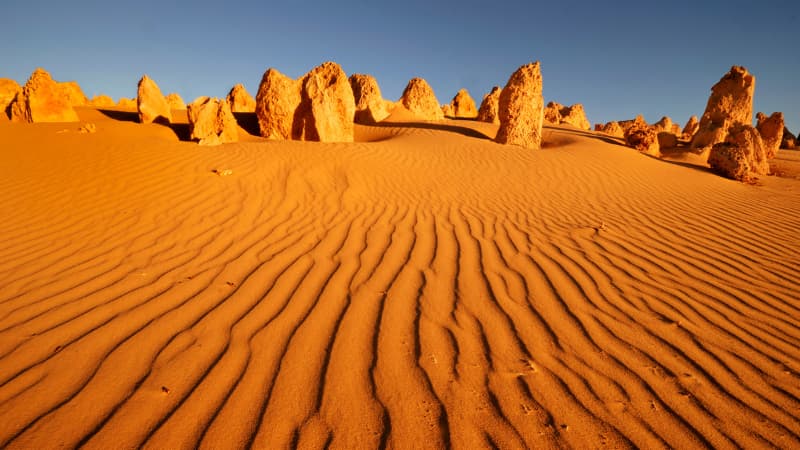 Orange sand of the Pinnacles desert meets the limestone rock formations