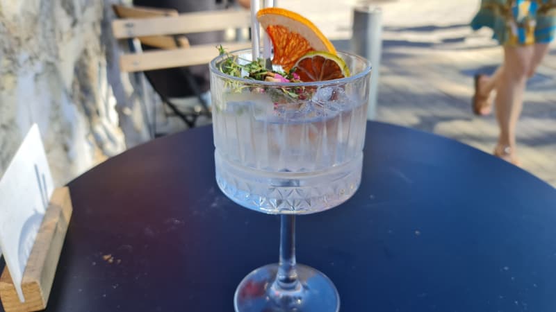 A gin Cocktail garnished with dried fruit sits on a table in Fremantle