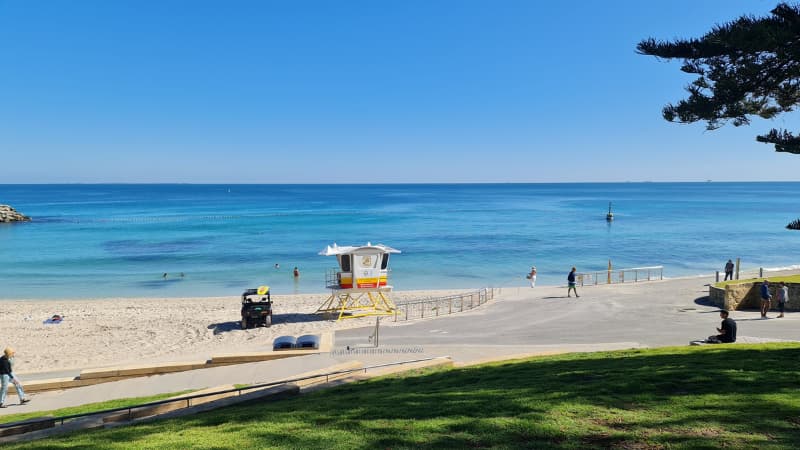A surf life saving tower stand on Cottesloe Beach. The water in the background is still and calm