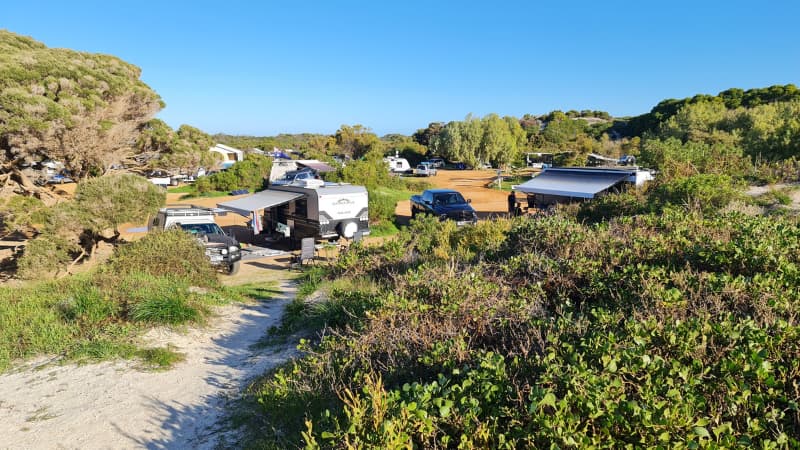 4WDs, tents and caravans set up at Sandy Cape Campground