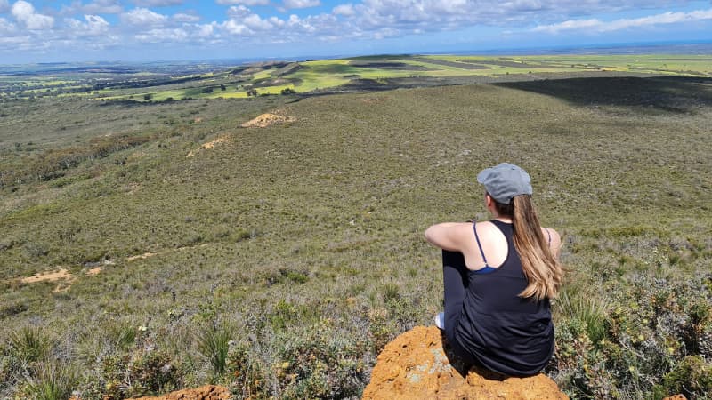 Nadia sits and takes in the views from Mount Lesueur