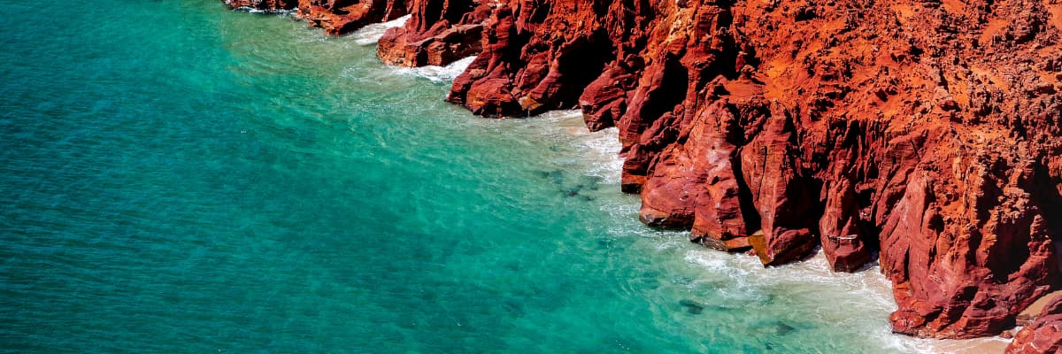 Red cliffs of the Kimberley Region meets the turquoise water of the ocean