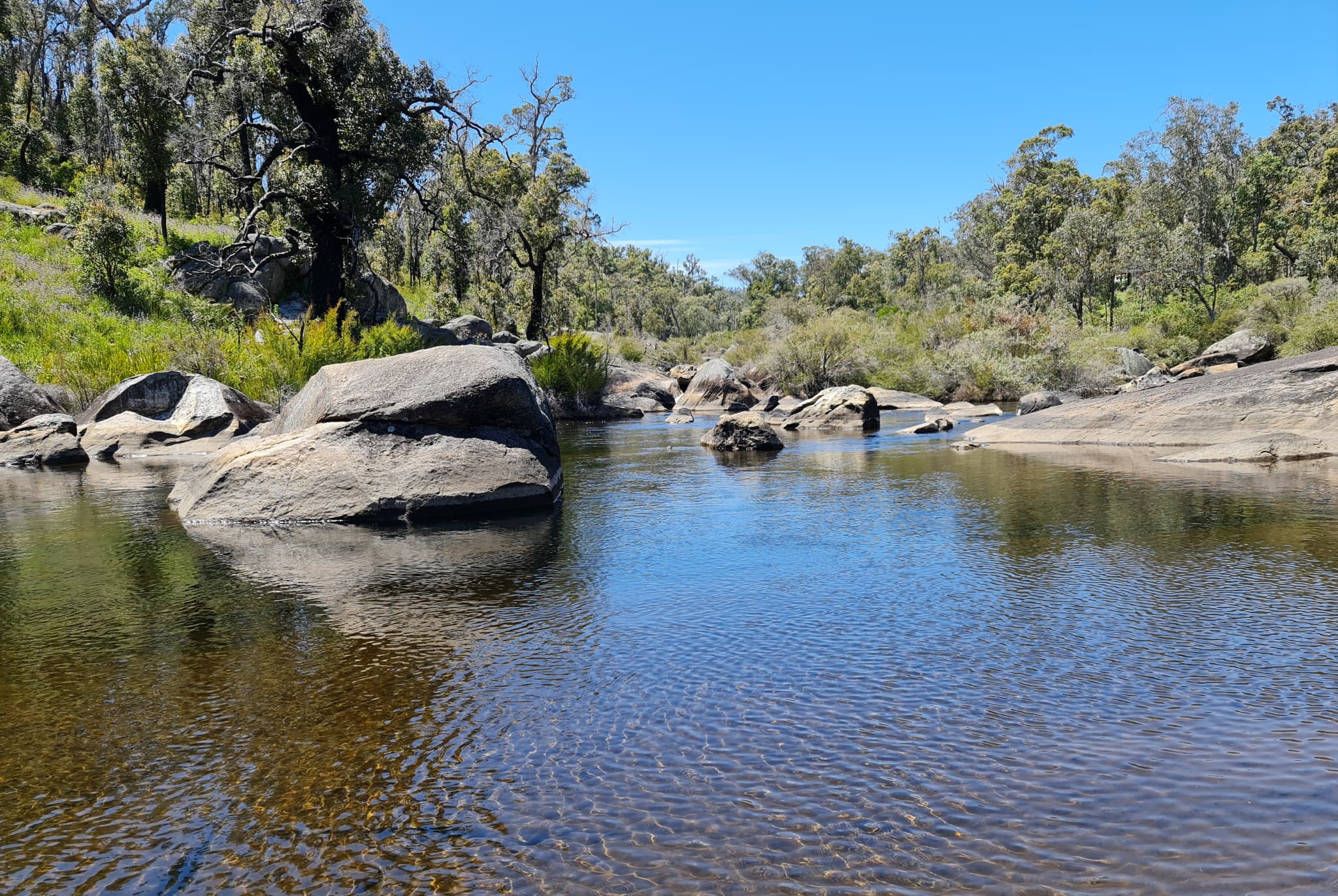 Water surrounded by rocks and trees at Wellington National Park