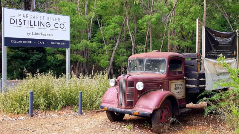 Red vintage truck parked next to Margaret River Distilling Co. sign - home of Giniversity