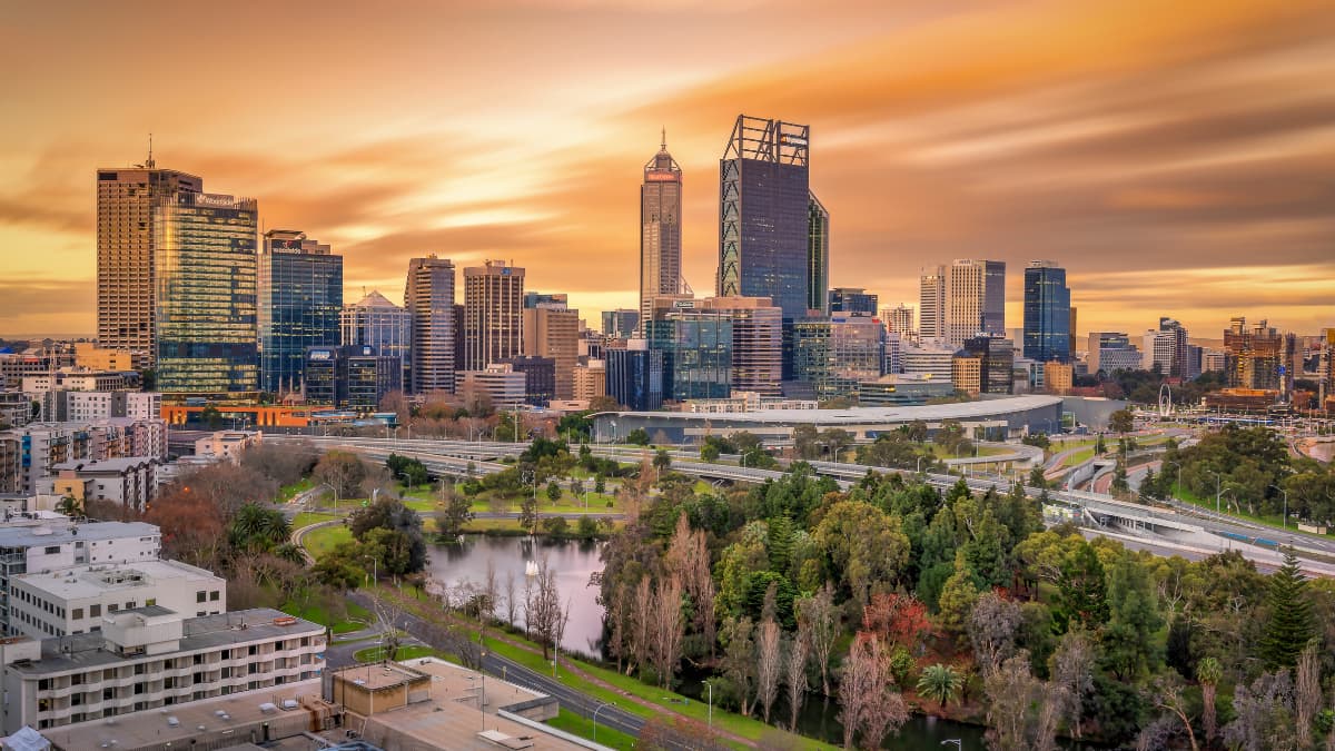 Perth city skyline at sunrise from Kings Park. The sky is golden.