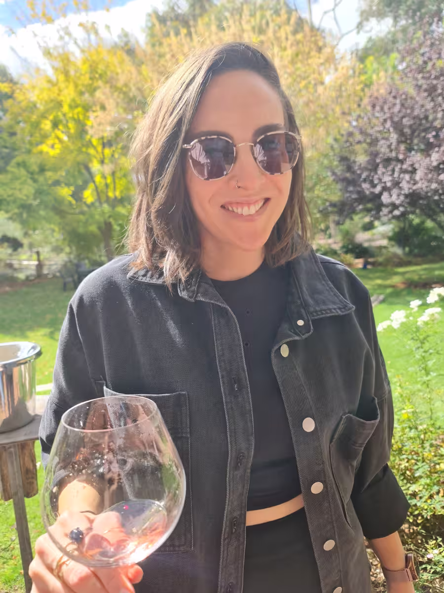 Margaret River Wine Tour (1) Nadia smiling in the sunshine during a wine tour in Margaret River, holding a nearly empty glass of rosé with trees in the background
