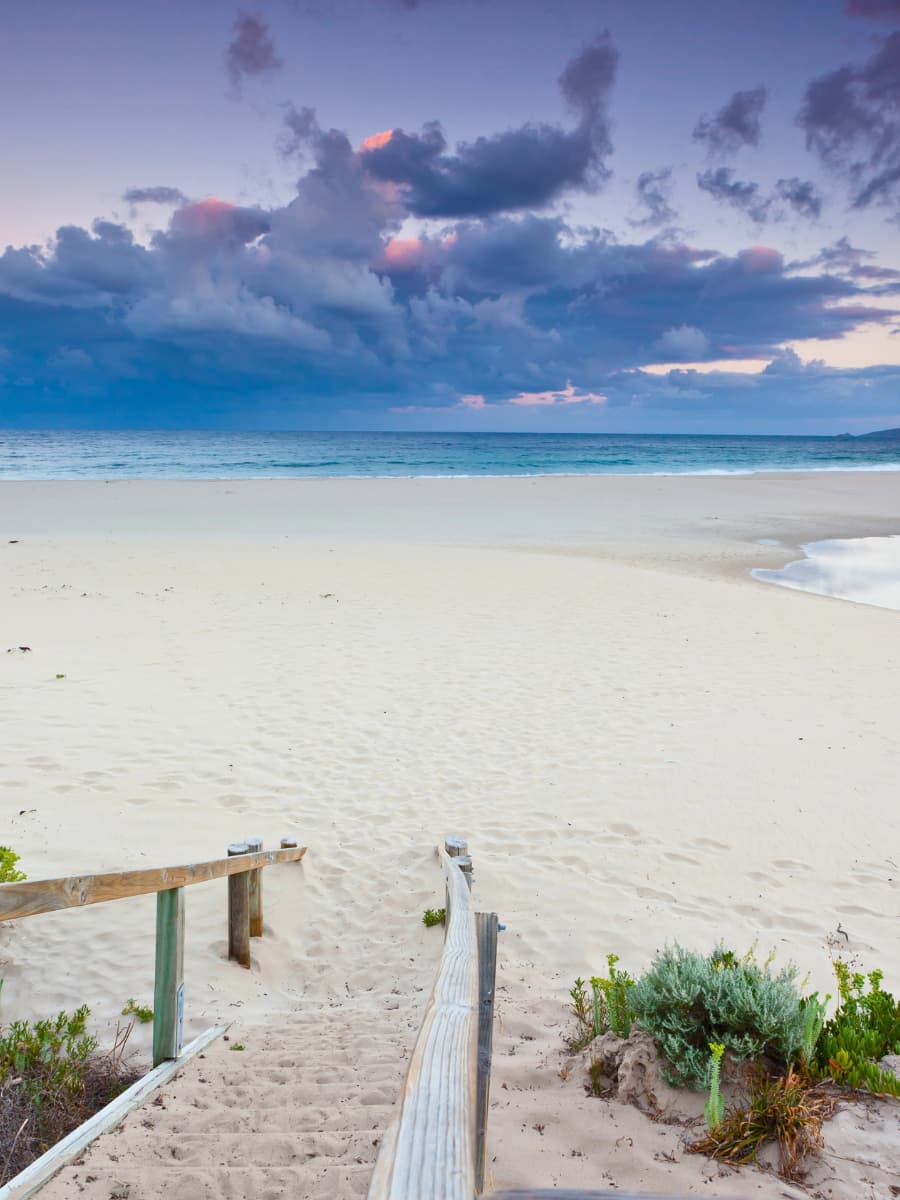 Margaret River Smiths Beach Wooden stairs leading down to the soft white sand of Smiths Beach in Margaret River, with moody clouds and a calm ocean at dusk.