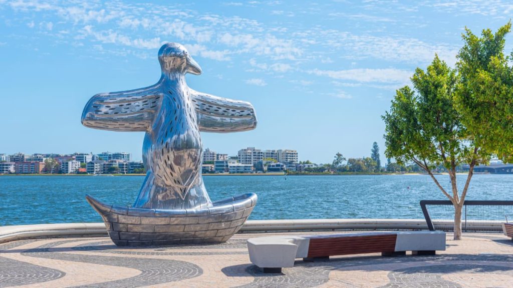 Elizabeth Quay First Contact sculpture on a boat at Elizabeth Quay in Perth with river and apartments in the background