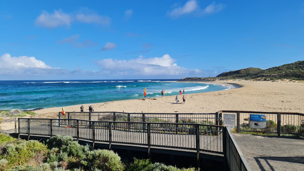 Surfers Point Surfers and beachgoers on the sand at Surfers Point, Margaret River under a bright blue sky