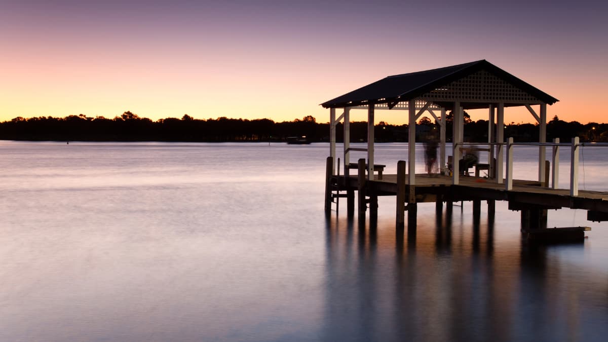 Wooden jetty over the calm river at sunset in Mandurah, Western Australia